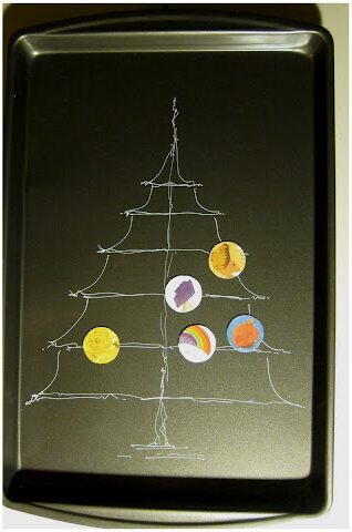 Colorful planet-themed Christmas ornaments hanging on a wire tree decoration for holiday celebration and festive decor.