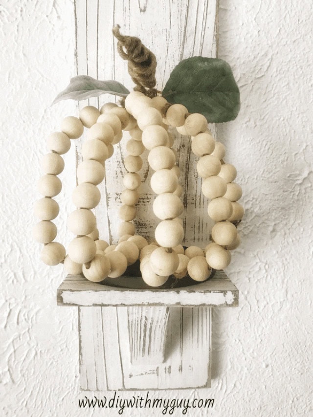 Wood bead pumpkin farmhouse decor with leaves and stem, perfect for fall and rustic holiday decorations. Handmade wooden craft for home accents and seasonal displays.