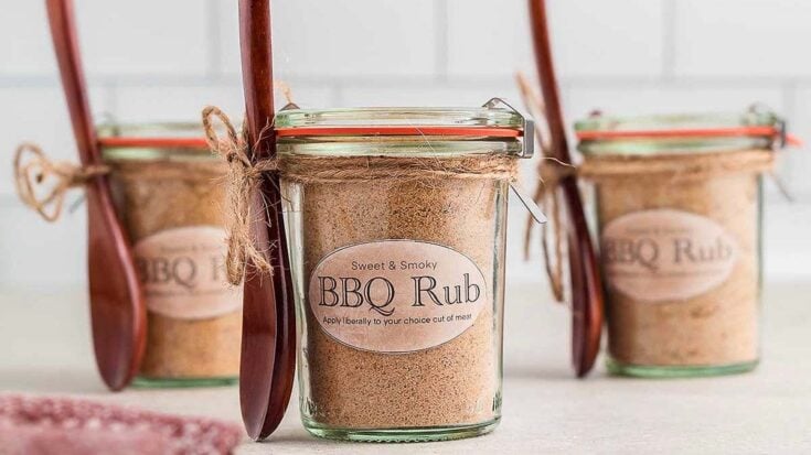 BBQ rub seasoning in glass jars with rustic spoons, ideal for grilling and meat seasoning, featured on A Hundred Affections for BBQ enthusiasts.