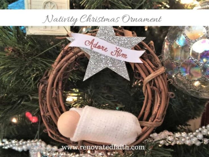 A Nativity Christmas ornament featuring a miniature Mary’s placenta in a woven basket with a silver star and "Adore Him" ribbon, perfect for holiday décor and religious-themed Christmas celebrating faith.