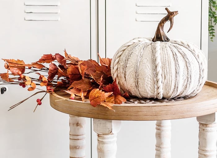 Pumpkin decor with cozy knitted texture and autumn leaves arrangement for fall home accents.
