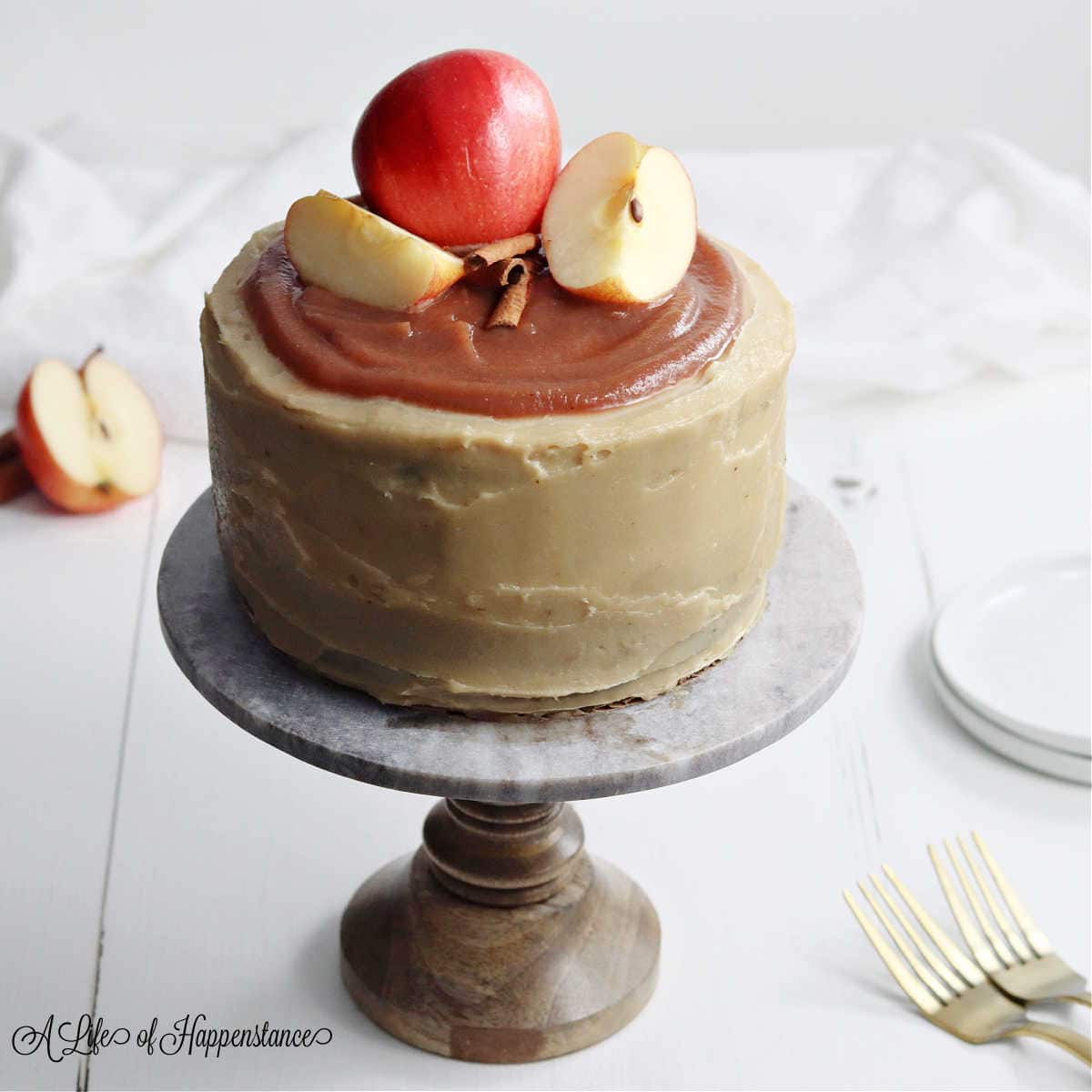 Creamy apple-flavored cake topped with fresh apple slices and chocolate shavings, perfect for celebrating special occasions with a touch of elegance and sweetness.