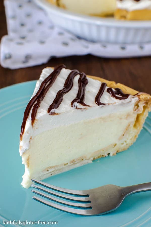 Fluffy gluten-free vanilla cheesecake topped with rich chocolate drizzle on a vibrant blue plate, perfect for desserts and celebrations.