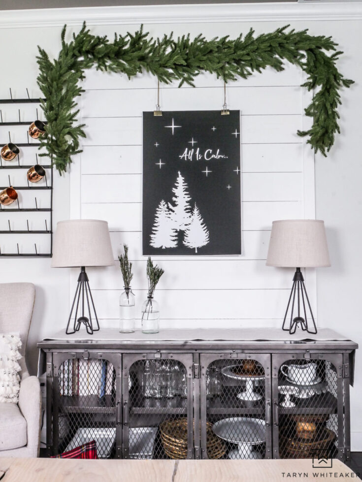 Festive Christmas home decor with a greenery garland, black and white wall art, and cozy table centerpiece, perfect for holiday seasonal decorating.