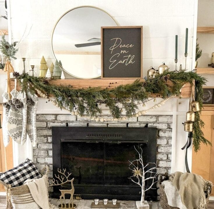 Festive Christmas fireplace mantel decorated with greenery, candles, stockings, and holiday accents for cozy holiday decor with a "Peace on Earth" sign, perfect for seasonal home styling.