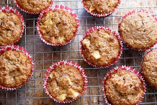 Delicious homemade apple cinnamon muffins in pink cupcake liners, cooling on a wire rack, perfect for cozy breakfast or snack, showcasing fresh baking from A Hundred Affections.