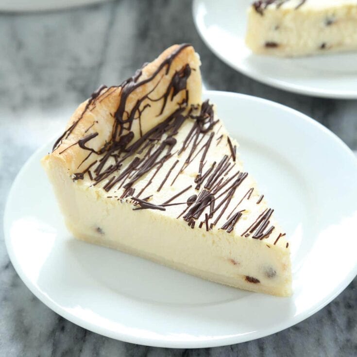 Cheesecake slice with chocolate drizzle on white plate, creamy texture, rich flavor, perfect dessert for celebrations, from A Hundred Affections bakery.