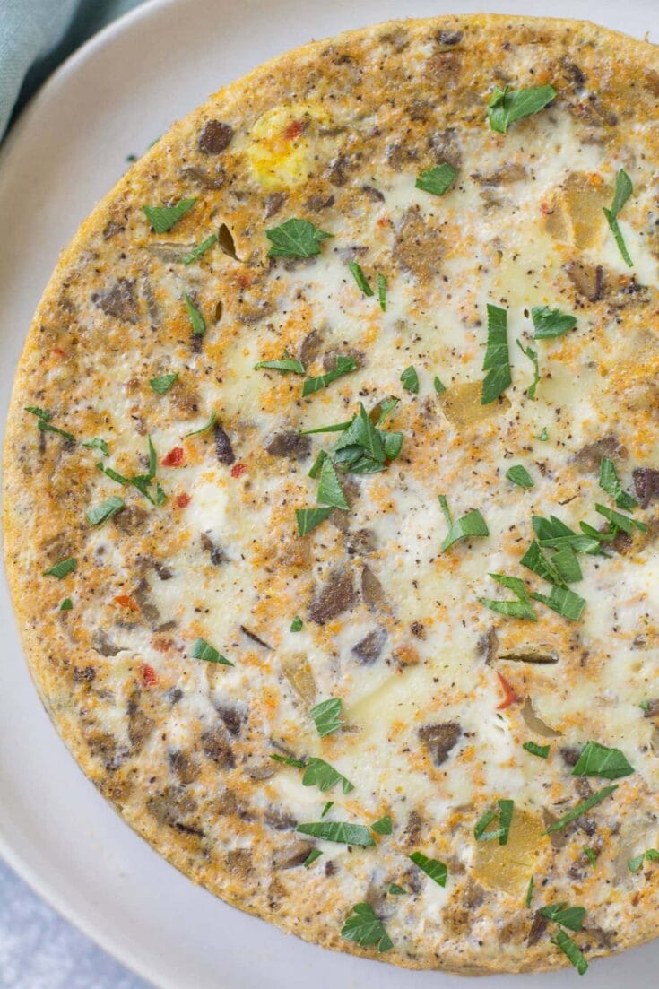 Savory breakfast calzone filled with seasoned beef, cheese, and herbs, baked to golden perfection, and garnished with fresh parsley, perfect for brunch or casual meals.