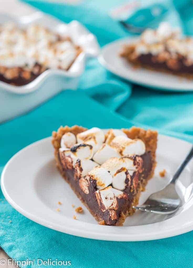 Decadent s'mores chocolate pie with graham cracker crust and toasted marshmallows on top. Perfect for dessert lovers and chocolate fans.