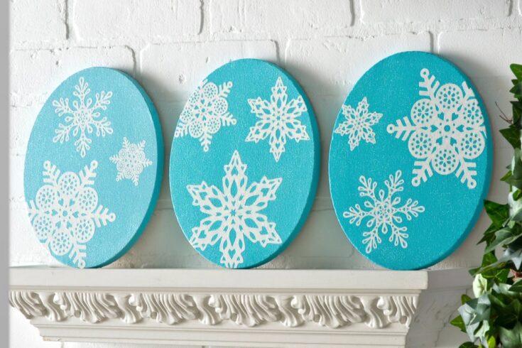 Colorful snowflake themed wall art with blue circular panels and white snowflake cutouts, creating a festive winter holiday decor for home or office.