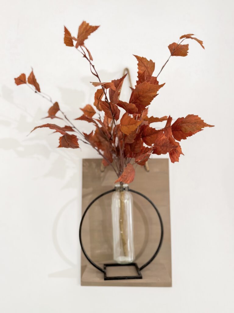 fall leaves in vase on shelf
