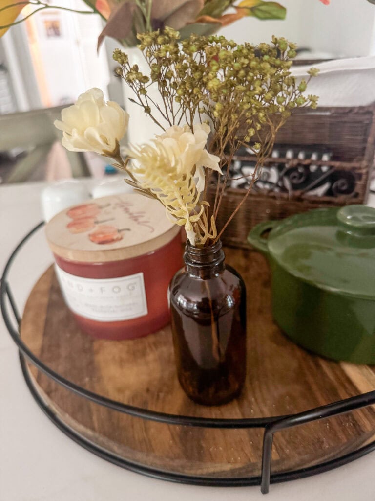Vintage amber glass vase holding dried cream and green botanical flowers on a wooden tray, decorative home accent, rustic floral arrangement, farmhouse decor, A Hundred Affections.