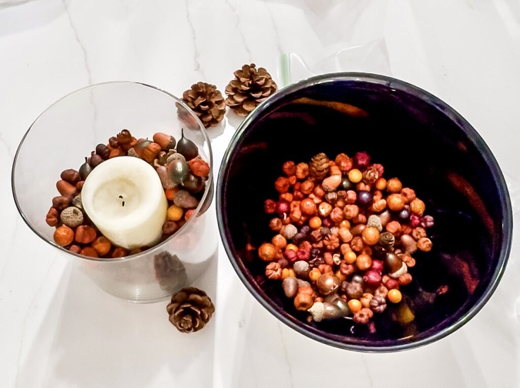 Colorful fall-themed candles with pinecones, perfect for cozy autumn home decor and seasonal decorations.