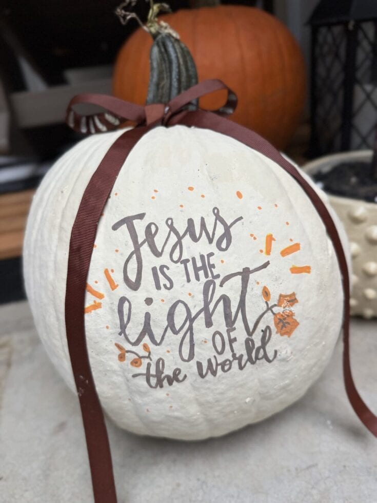 Pumpkin with inspirational fall decor and handwritten "Jesus is the light of the world" message for seasonal home decoration.