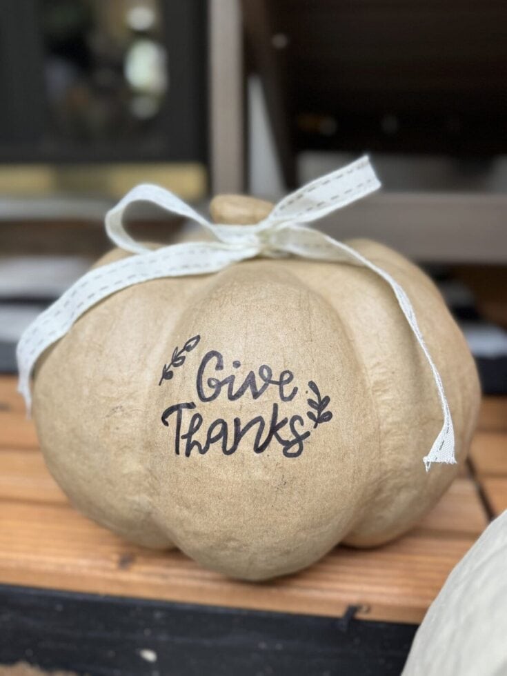 Aesthetic gift decorated pumpkin with "Give Thanks" message, tied with a white ribbon, perfect for Thanksgiving, autumn decor, gratitude celebration, craft store, holiday home decoration.