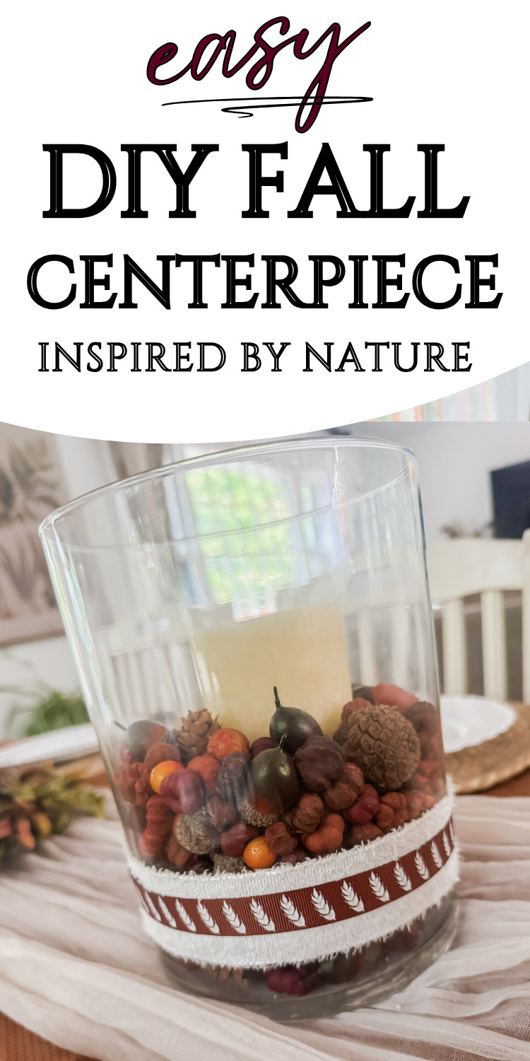 Vase centerpiece with fall-inspired decor featuring berries, pinecones, and a white candle, perfect for autumn home decor and Thanksgiving table settings.