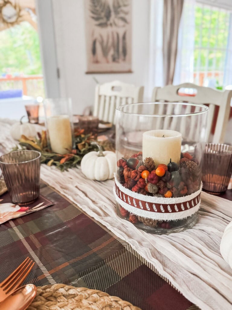 Festive fall table centerpiece with candles, pumpkins, and autumnal decor for cozy dining at A Hundred Affections.