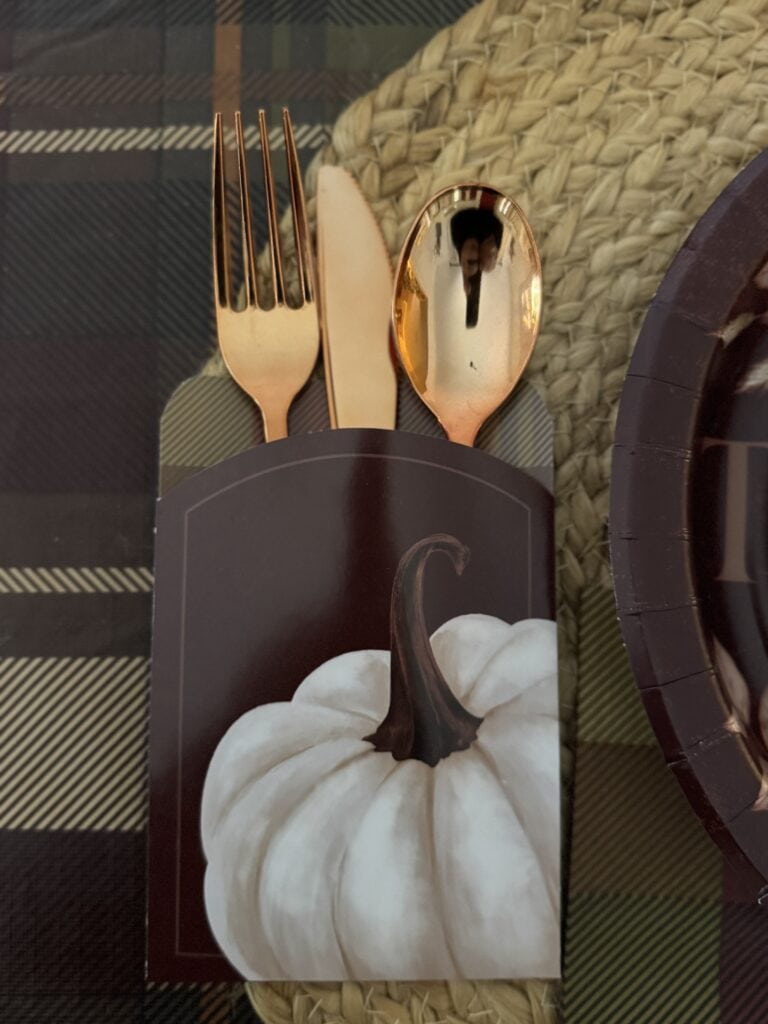 Elegant pumpkin-themed tableware with rose gold cutlery and autumn-inspired decor, perfect for cozy fall celebrations and Thanksgiving gatherings.