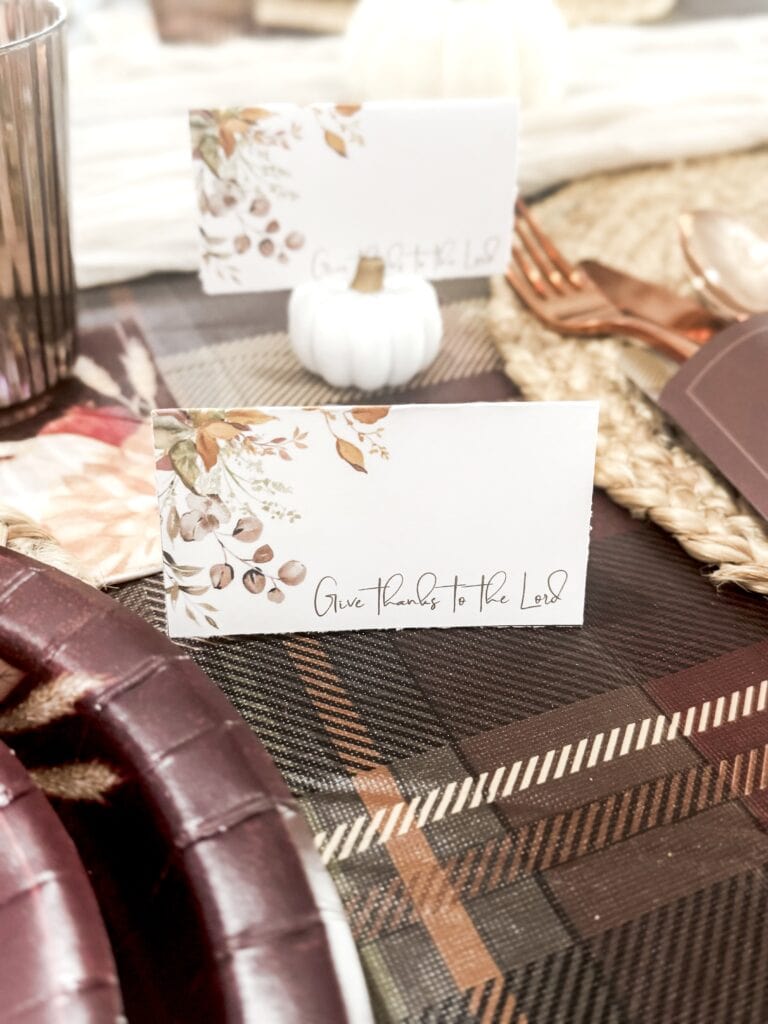Rustic fall tablescape with "Give Thanks to the Lord" place cards, white pumpkin, and seasonal decor for Thanksgiving celebration.