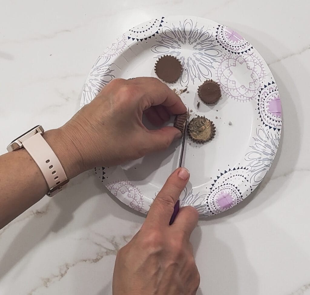 Cut peanut butter cups being prepared on a decorative plate, perfect for gift giving or special occasions, from A Hundred Affections.