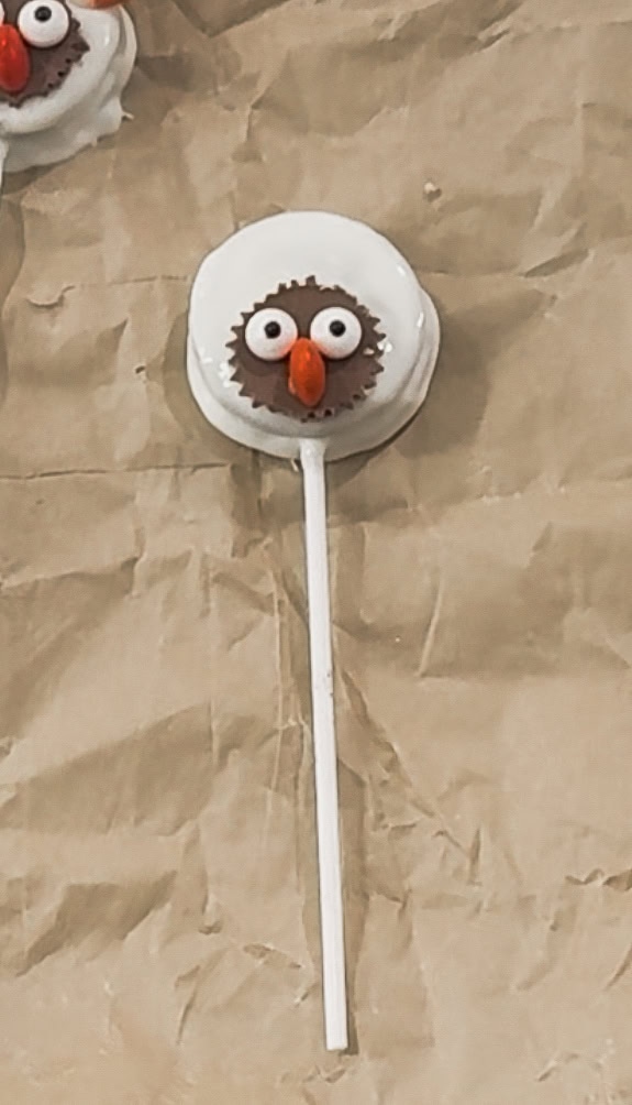 Cute turkey cake pop with whimsical eyes and orange beak, perfect for fall and Thanksgiving celebrations.