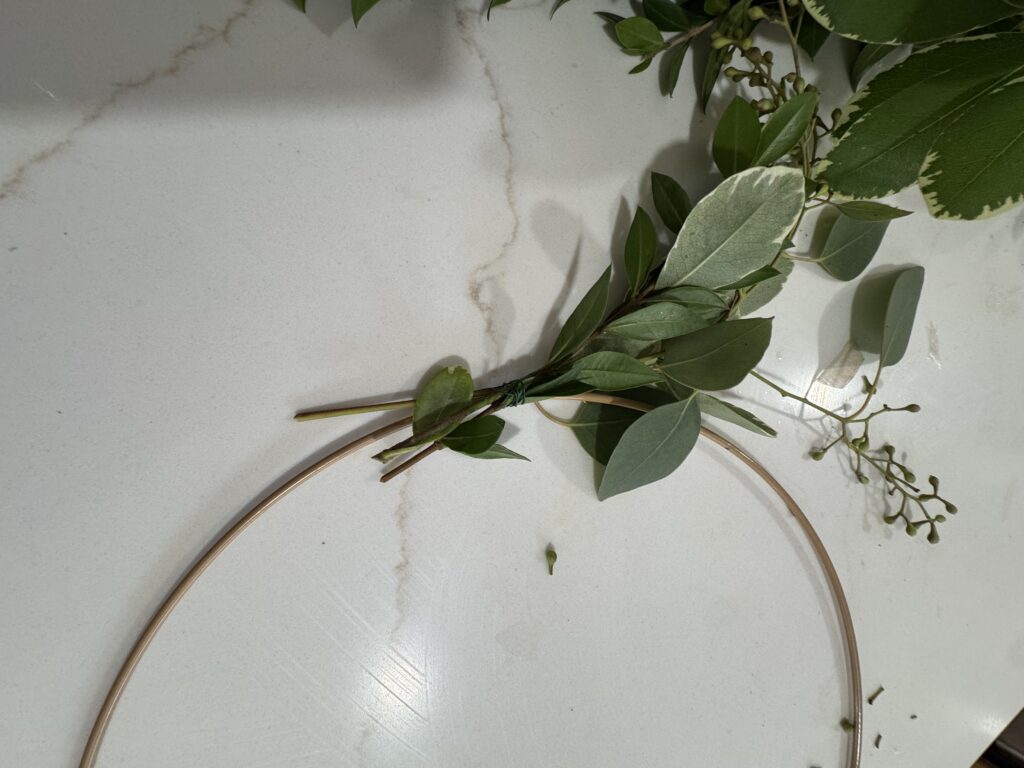 Lush greenery and delicate foliage arranged on a white marble surface, showcasing natural and botanical decorations for home or event styling.