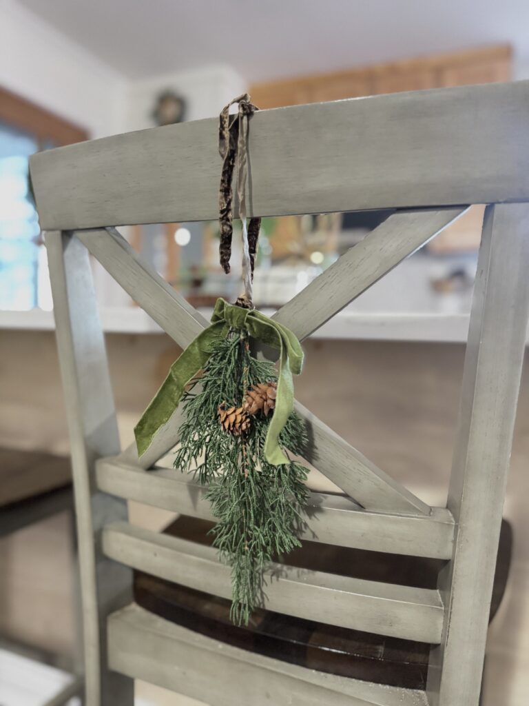 Wooden chair decorated with a festive greenery garland for holiday home decor.