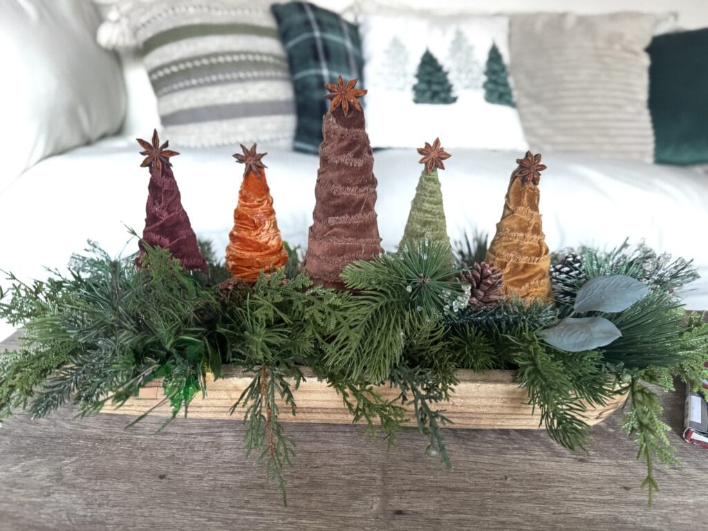 Colorful cone-shaped Christmas decorations with star anise toppers in a festive greenery arrangement.