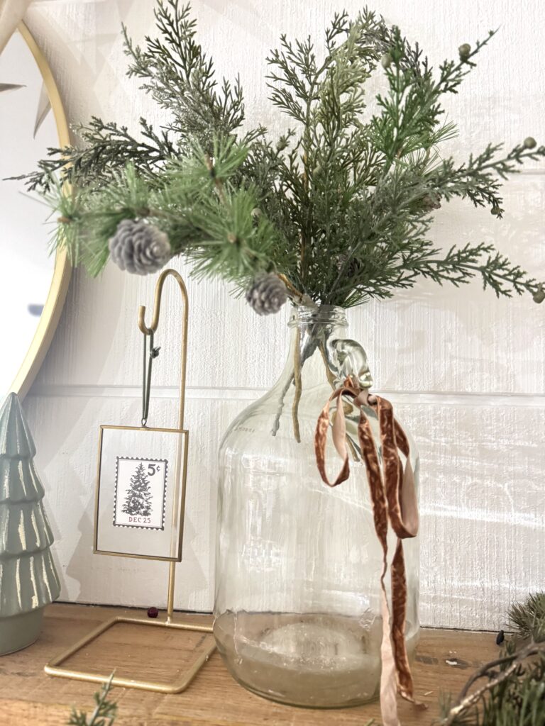 Pine branch in a glass vase with a ribbon, rustic holiday decor, Christmas table centerpiece, winter holiday design, seasonal decorations for festive home aesthetic.