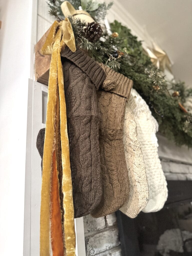 Cozy Christmas stockings hanging on a mantel with festive greenery and decorations, perfect for holiday home decor and seasonal cheer.