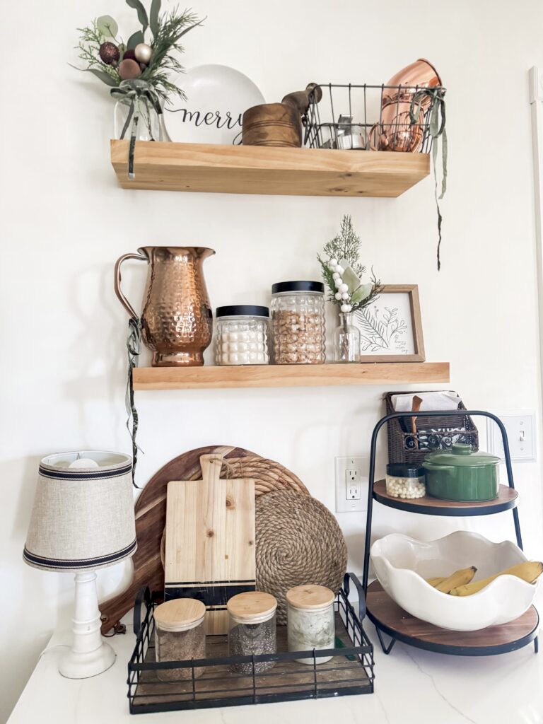 Decorative kitchen shelf with jars, bowls, and greenery for home organization and cozy aesthetic in rustic style.