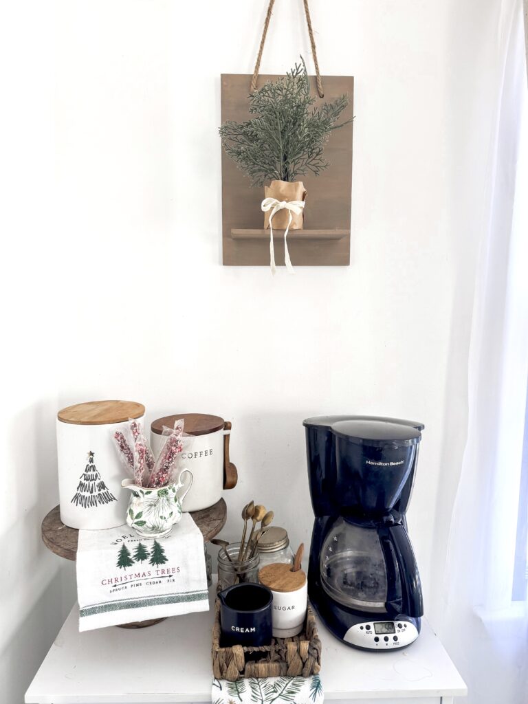 Decorative kitchen coffee nook with Christmas-inspired teapots, jar, and coffee maker.