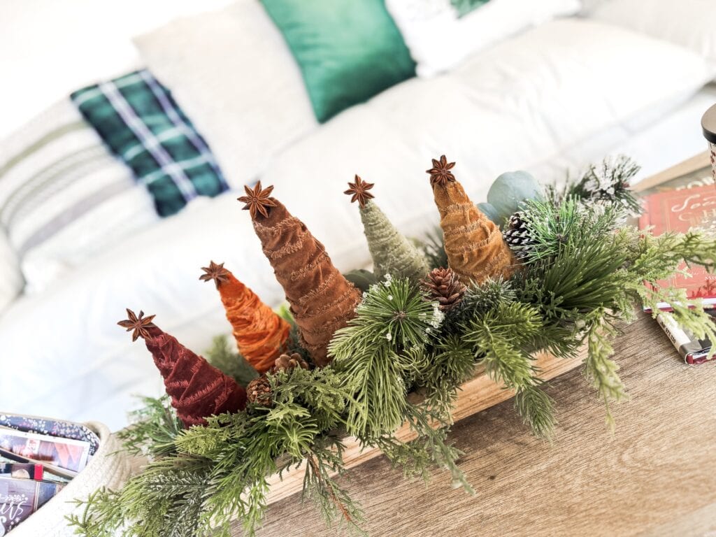 Colorful Christmas cone craft wreath with greenery and pinecones for holiday home decor.