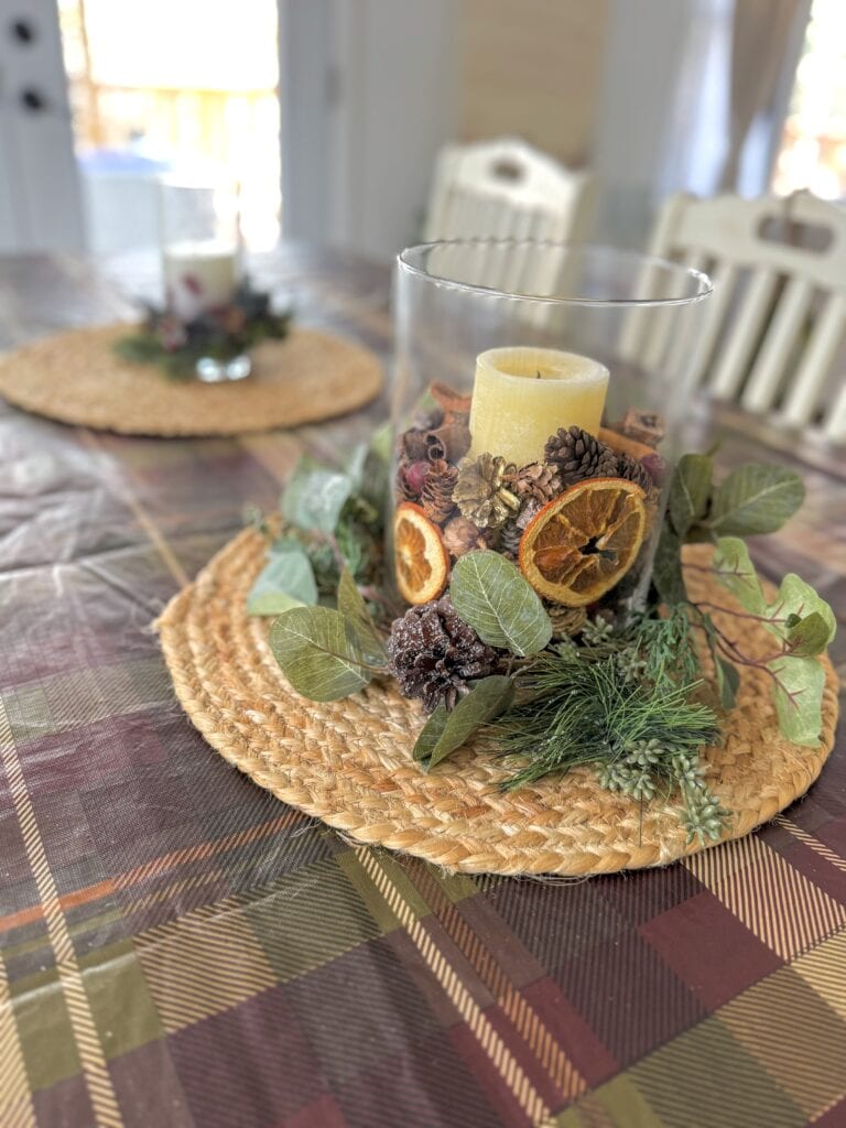 VIntage holiday centerpiece with candles, pinecones, dried oranges, and greenery, perfect for festive table decor, at A Hundred Affections.