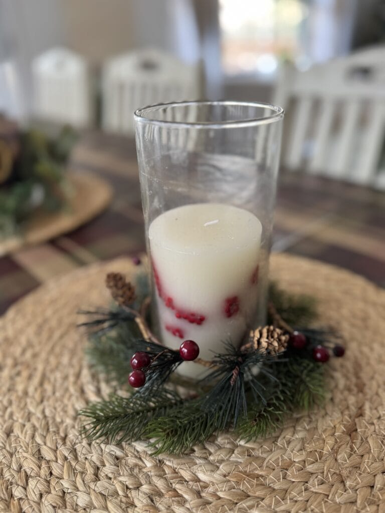 Festive holiday holiday candle centerpiece with red berries and pine branches for Christmas decorations.
