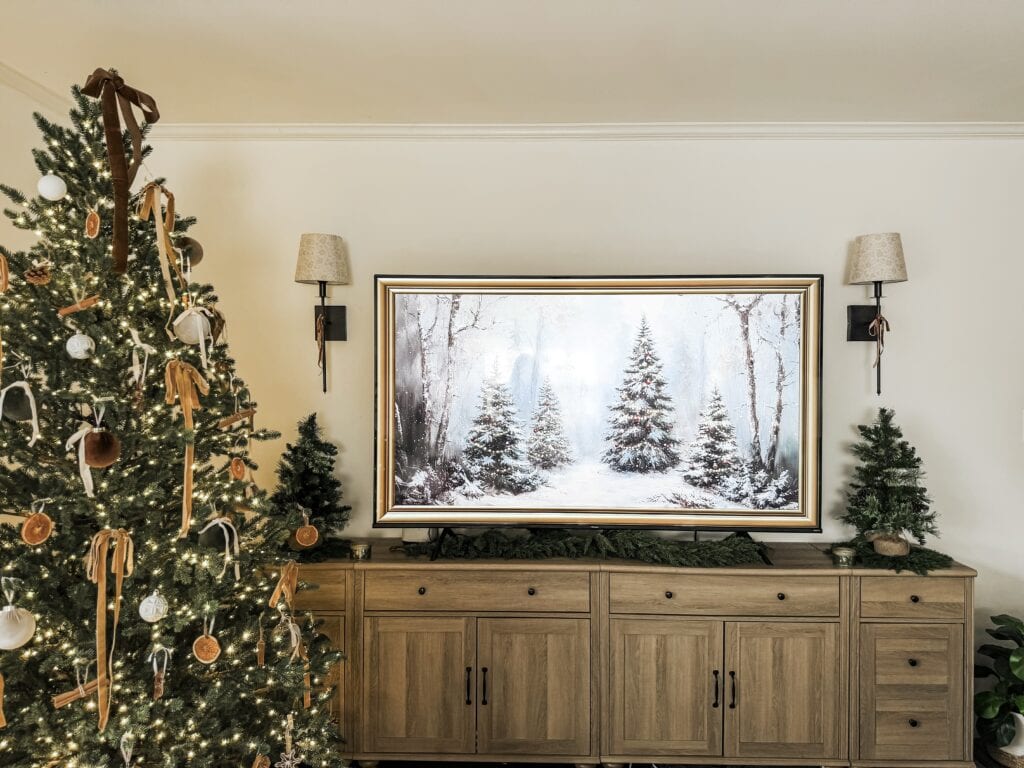 Ornament-filled Christmas tree with warm white lights on a holiday living room setup.