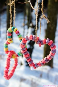 Colorful handmade heart garlands hanging outdoors in a snowy winter scene, perfect for [valentine's Day], [romantic decor], and [handmade gifts] for expressing love and affection.