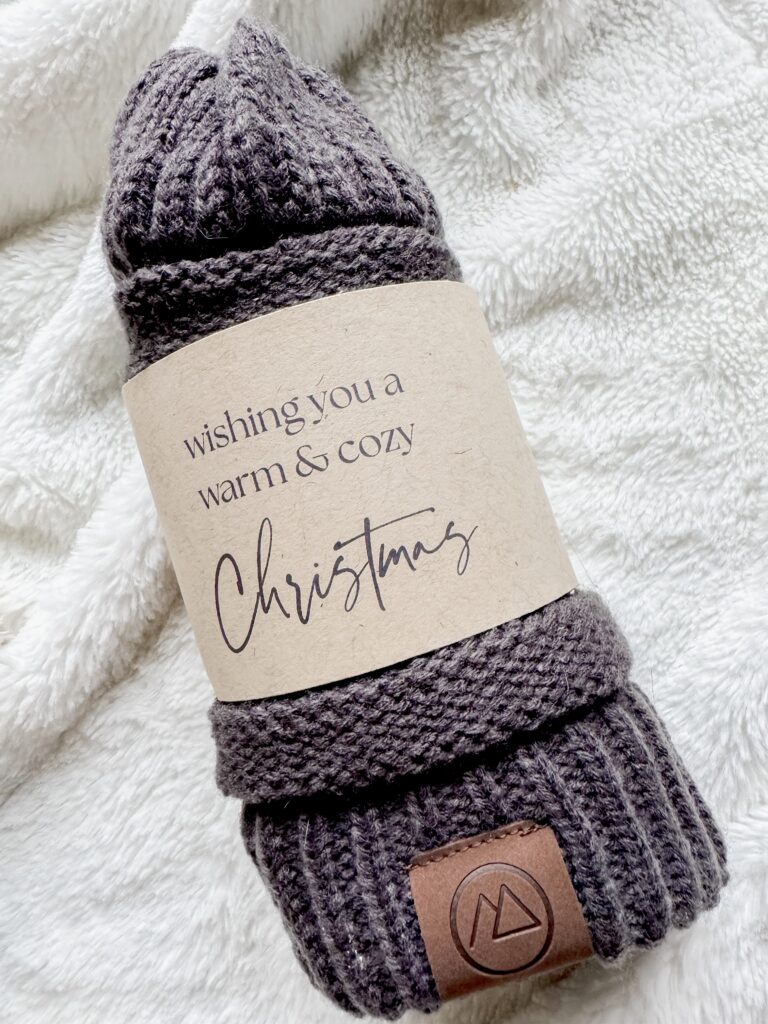 Soft, gray knitted Christmas socks featuring a heartfelt holiday message on the label, perfect for winter warmth and festive gift-giving.