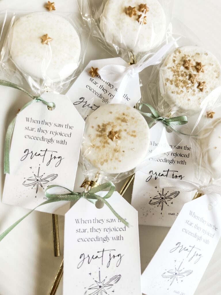 Decorative white cake pops with star and glitter sprinkles, individually wrapped in clear cellophane and tied with elegant ribbons. Perfect for holiday celebrations and gifting.