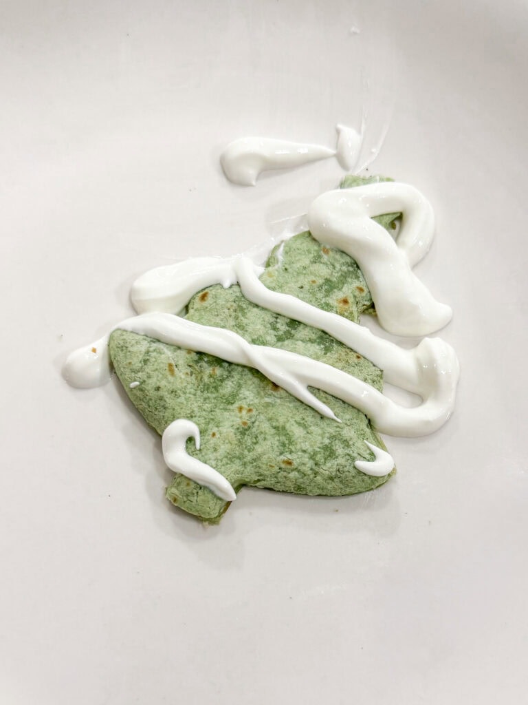 Delicious green heart-shaped cookie topped with white icing, perfect for Valentine's Day or special occasions, on a clean white surface.