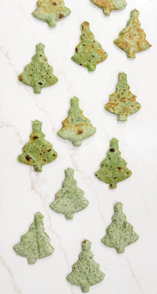 Delicious matcha-flavored cookies shaped like Christmas trees, perfect for holiday treats or festive baking moments. Crafted with natural ingredients and vibrant green color.