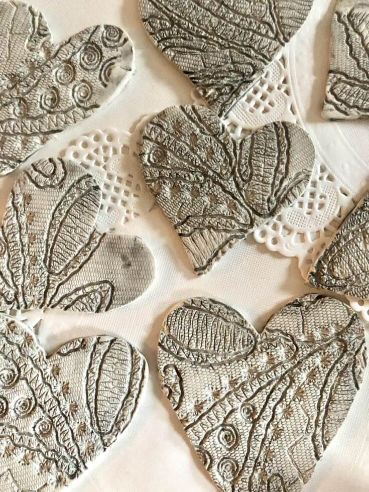 Decorative hearts with embossed lace design in silver and white for romantic wedding or anniversary celebrations.