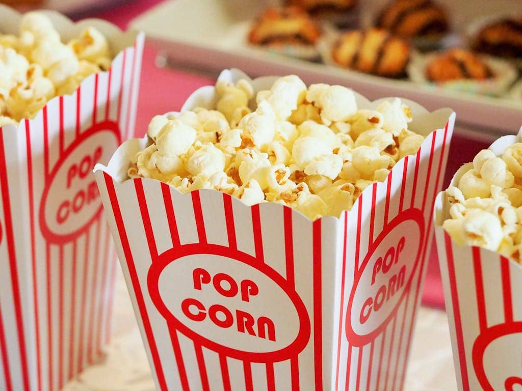 A close-up of fresh popcorn served in classic striped popcorn boxes, perfect for movie nights and snacks.