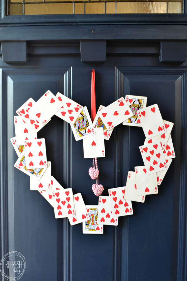 A creative heart-shaped wreath made from playing cards featuring hearts and queens, perfect for Valentine's Day decor and expressing love creatively.