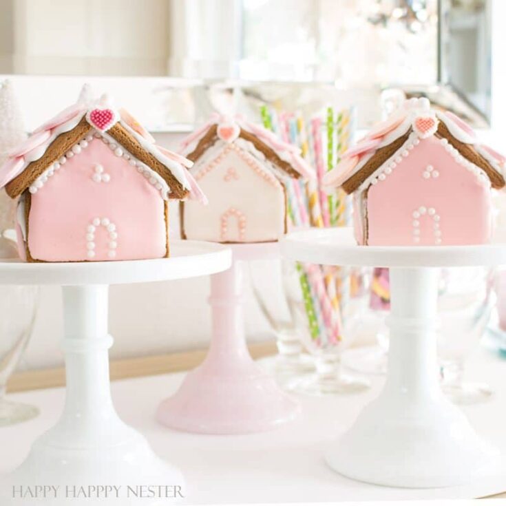 Decorative pink and white gingerbread houses for birthdays or special occasions, featuring detailed icing and festive decorations. Perfect for celebration treats.