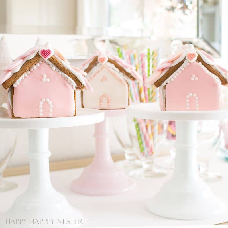 Decorative pink and white gingerbread houses for birthdays or special occasions, featuring detailed icing and festive decorations. Perfect for celebration treats.