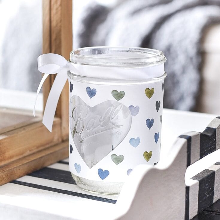 Decorative glass candle holder with heartfelt "Love" message and colorful heart pattern, perfect for romantic gifts or home decor.