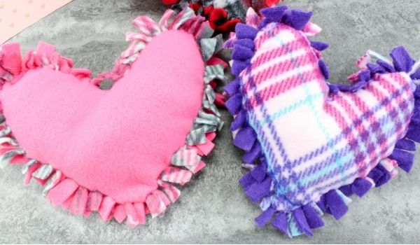 Soft pink heart plush pillow with ruffled trim, ideal for home decor, cuddly gifts, and heartfelt sentiments at A Hundred Affections.