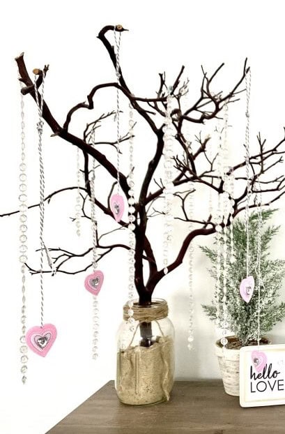 A decorative tree with hanging pink heart ornaments and crystal accents, creating a romantic and charming display. Perfect for love-themed decor and special occasions.