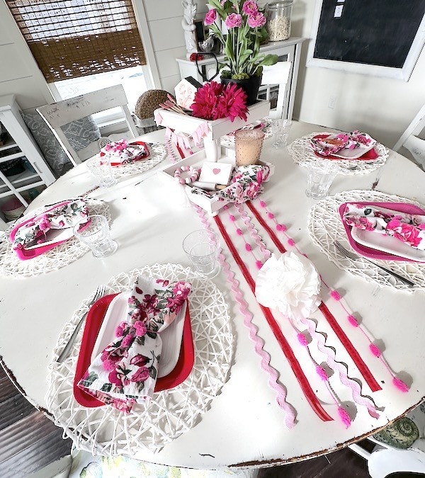 Beautiful Valentine's Day table decor with pink and red accents, floral napkins, and romantic touches for a special celebration.